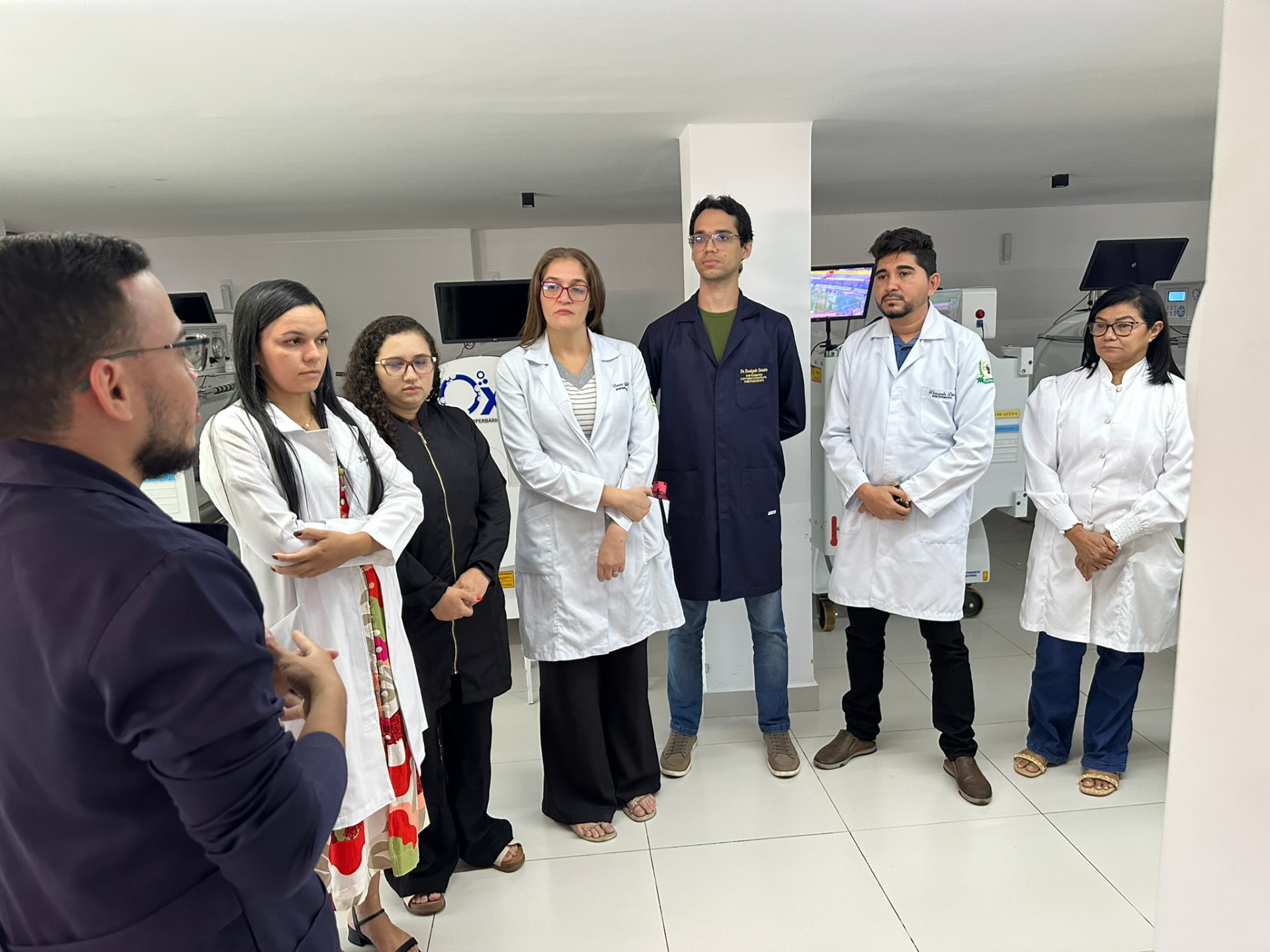 Alunos da turma de Dermatologia e Feridas acompanhando explicação do professor entre equipamentos clínicos
